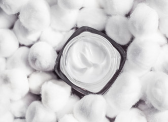 Luxury face cream for sensitive skin and white cotton balls on background, spa cosmetics and...