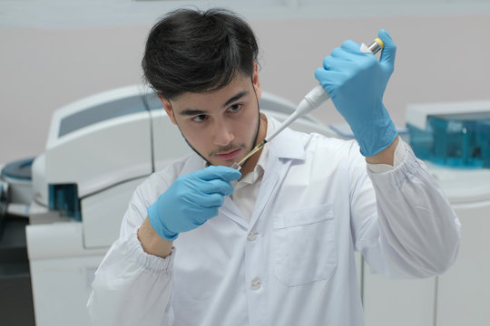 Man in white uniform in laboratory work on analize.