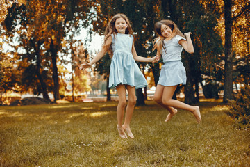 Beautiful girls on a blue dresses. Friends have fun in a summer park