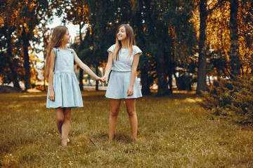 Beautiful girls on a blue dresses. Friends have fun in a summer park
