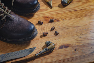 flat lay layout of men's leather accessories. Leather high boots with a knife in the bootleg - a...