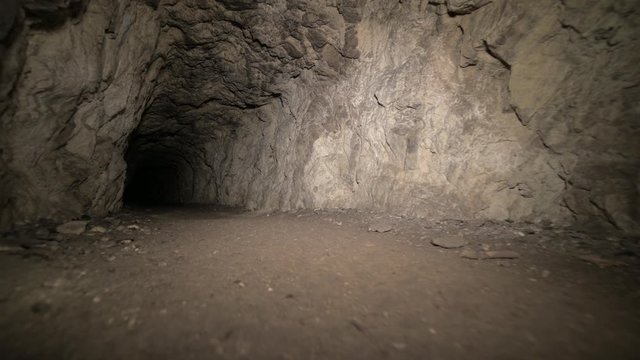 Speleology artificial cave dark tunnel excavation underground. Old adit for the extraction of metal and rocks