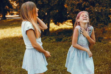 Beautiful girls with a colorful dry paints. Friends have fun in a summer park