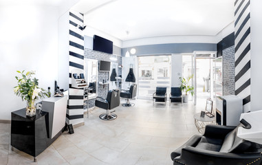 Reception in a beauty salon with desk,plant and banners. Hair salon interior.