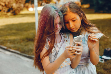 Beautiful girls with a colorful dry paints. Friends have fun in a summer park