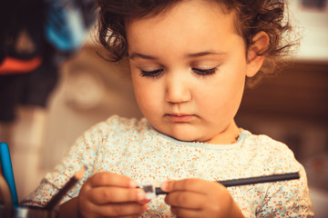 Cute small girl using pencil sharpener.