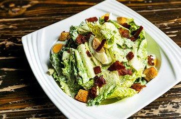 Healthy Caesar salad made of fresh vegetables on wood table
