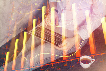 Forex graph with businessman working on computer in office on background. Concept of analysis. Double exposure.