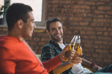 Delighted joyful men cheering with their drinks