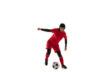 Obraz na płótnie Canvas Arabian female soccer or football player isolated on white studio background. Young woman kicking the ball, training, practicing in motion and action. Concept of sport, hobby, healthy lifestyle.