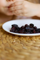 little girl eating raisins. natural vitamins
