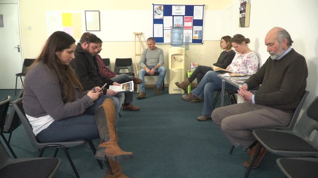 4K: Group of People sat in Waiting room awaiting Healthcare appointments. Could be a Doctor or dentist surgery clinic.&nbsp;