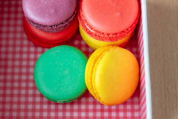 French delicious dessert. Sweet macaroons in a pink gift box on wooden table