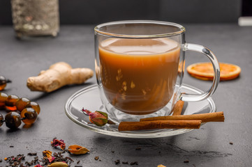 Traditional Indian masala tea chai. Cinnamon, anise, cardamom, sugar next to a black textured background