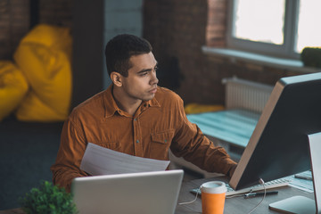 Smart concentrated young man working in the office