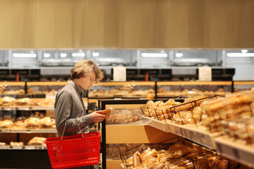 Teenager choosing bread from a supermarket	