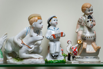 Assortment of rare porcelain figurines on glass shelf
