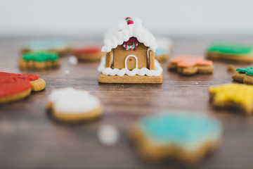 festive gingerbread house and cookies in different colors and shapes