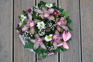 Top view of bouquet of orchids on wooden background.