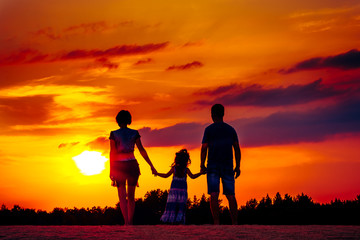Fototapeta na wymiar Happy family on meadow at summer sunset