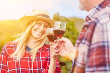 Paar mit Glas Rotwein bei Weinprobe im Weinberg