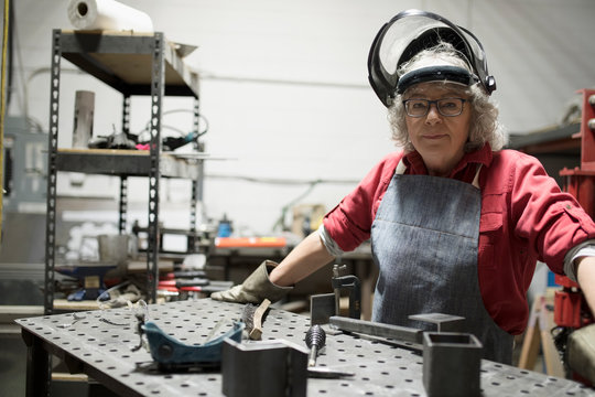 Portrait confident senior female welder at workbench in workshop