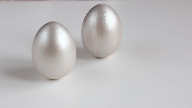 Easter eggs painted with silver paint on a white background. Easter holiday.