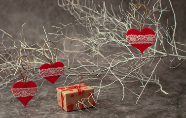 Holiday background for Valentine's Day on a gray cement background with white painted branches and a sheet of paper for text