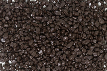 Confectionery dark chocolate in dragee sprinkled with a smooth layer
