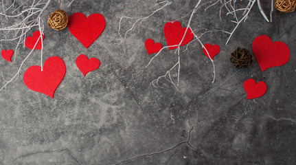 Holiday background for Valentine's Day on a gray cement background with white painted branches and a sheet of paper for text
