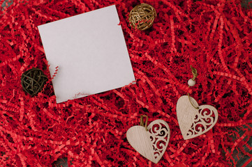 Holiday background for Valentine's Day on a gray cement background with red chopped wrapping paper and hearts.