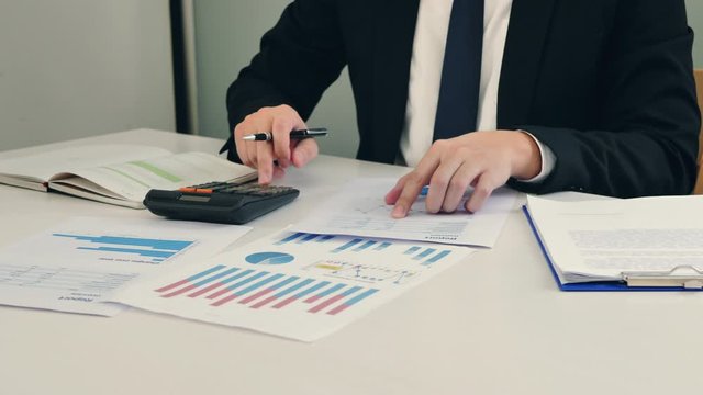Business man working with Report chart and calculate budget in office planning new business project
