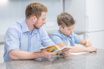 Father helps son do schoolwork at home