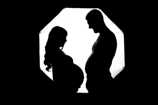 profile of a guy and a pregnant girl in a photo studio