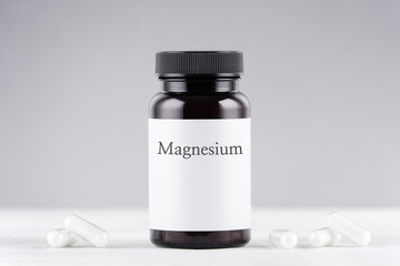 nutritional supplement magnesium bottle and capsules on gray - obrazy, fototapety, plakaty