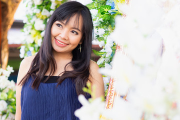 Young Asian woman wearing blue dress that posing and smiling happily.