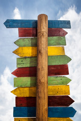 Multicolor pole guidepost with lots of destinations arrows