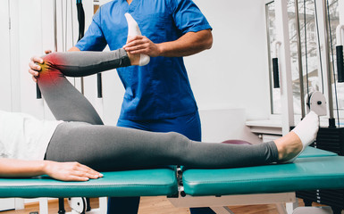 chiropractor doing an exercise to treat a patient's knee. Knee pain, knee injury