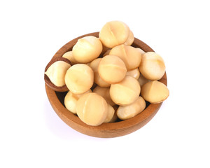 Macadamia nuts in wooden bowl on white background top view