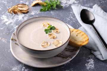 Champignon puree soup with white bread toast, garnished with fresh parsley and fried mushroom slices.View from above.