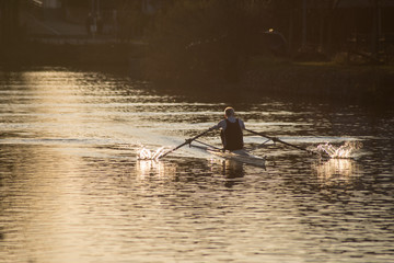 Naklejka premium portrait on back view of old man rowing on the river
