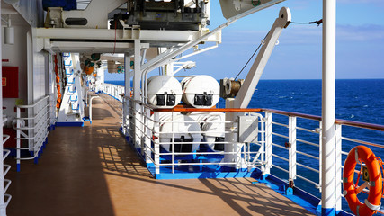 walk deck on a cruise ship. safety on the ship, lifeboat, liferafts, lifebuoys. liferaft station. blue ocean. white ship in the blue ocean. large cruise ship