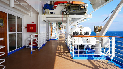 walk deck on a cruise ship. safety on the ship, lifeboat, liferafts, lifebuoys. liferaft station. blue ocean. white ship in the blue ocean. large cruise ship