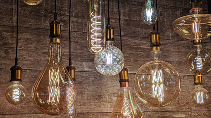 Burning light bulbs with original beautiful spirals on a warm brown background. Disain, beauty and comfort indoors.