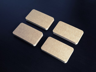 Blank kraft business cards on black wood table background.
