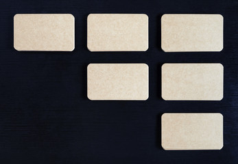 Photo of blank vintage business cards on black wooden background. Flat lay.