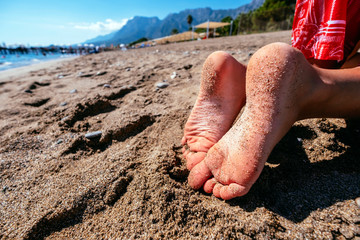 Young girls legs on beach. Summertime relax. Womans or kids feet on beach. Vacation travel concept. Happy people. Banner with copyspace. Stock photo.