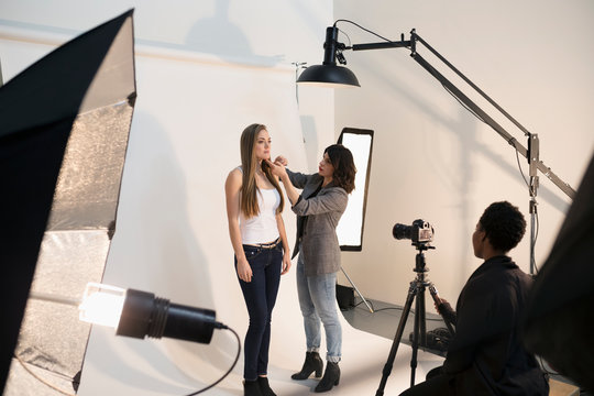 Female Makeup Artist Applying Makeup To Model, Preparing For Photo Shoot In Studio