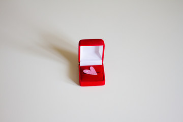 gift red box with a heart on a light background. holiday concept, for example, Valentine's Day, women's day. the concept of love and feelings. gift. space for text. the view from the top.