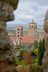 Fototapeta na wymiar Antique church seen through a hole in the wall of Trujillo, Spain